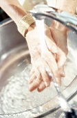Frau mit lackierten Fingernägeln wäscht sich die Hände