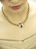 Close-up of woman wearing gold necklace 