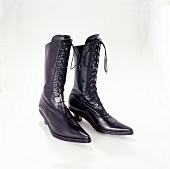 Pair of black boots with lace on white background