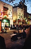 Tourists listening to street musician in front of cafe, Dublin, Ireland