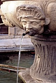 Wasserspeier eines Brunnens in Form eines Männerkopfes.