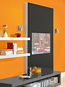 Medienwand in Schwarz und Regale von der Seite, Wand orange
