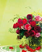 Großer Strauß mit roten und rosanen Rosen in einer grünen Vase