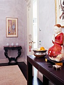 Braunes Sideboard im Barockstil, darauf plaziert ein Buddha: Stilmix
