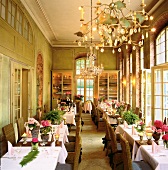Laid tables in ballroom with chandeliers