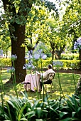 Businessman sitting in the garden and reading paper, rear view