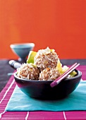 Steamed meatballs wrapped with chopped peanuts and rice in bowl