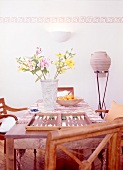 Backgammon game, vase, fruit bowl on large wooden table with frescoed wall