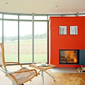 Kaminzimmer mit weitem Ausblick in die Natur durch Fensterfront.