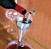 Rotwein wird durch e. Trichter aus Edelstahl gegossen: Dekantieren