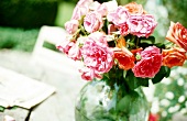 Strauß roter und rosaner Rosen in einer Vase auf einem Tisch Garten.