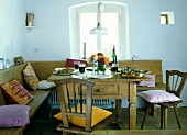 Country style laid table with chairs in front of window in dining room