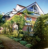 Zweistöckiges Haus mit Dachgeschoss im üppigen Garten, viele Balkons