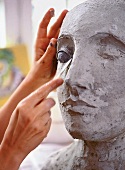 Papierkünstlerin A. Meincke-Nagy bei Arbeit, formt Gesicht mit Spatel