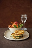 Buckwheat biscuits with bowl of salad on plate