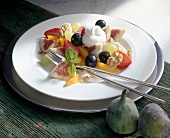 Fruit salad with walnuts and cream on plate