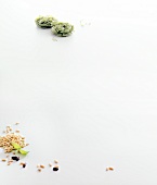 Raw green tagliatelle with pine nuts on white background