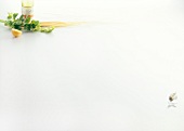 Bottle, parsley, raw spaghetti and halved lemon on white background, copy space