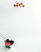 Strawberry sauce in pan and strawberries on white background, copy space