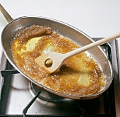Melted butter and sugar in frying pan on stove