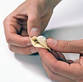 Close-up of hand pressing edges of dough circle