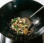 Ingredients being fried in wok while preparing bami goreng pasta, step 4