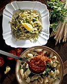 Tagliatelle with asparagus and conchiglie with tomato sauce on two plates