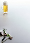Blood sausage and chives on cutting board and glass of beer on white background