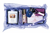 Geschenk-Sortiment: Beauty-Produkte auf violettem Seidenpapier