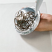 Design made of chocolate with piping bag on bowl wrapped with aluminium foil