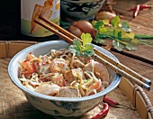 Noodles with tofu and shrimp in bowl with chopsticks