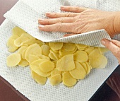 Pat drying with tissue on sliced boiled potatoes