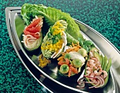 Variety of stuffed avocados with chicken, salad, crab and carrots on serving plate