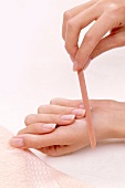 Close-up of woman filing her nails with nail file