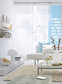 Wohnzimmer mit weißem Sofa, hellblaue Wand mit Schrift