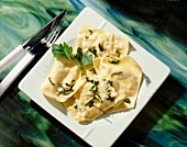 Ravioli with cheese and leek filling on square dish