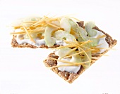 Close-up of two crisp breads with yogurt, perennial celery and carrot strips