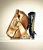 Close-up of leather bag with rivets, golden wristwatch and sequined ballerina shoes