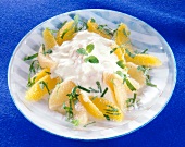 Close-up of grapefruit and orange salad with yogurt and lemon balm leaves