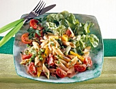 Close-up of pasta salad with tomatoes, peppers, peas and yogurt sauce