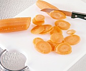 Close-up of carrot cut into slices on white chopping board