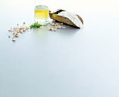 Flour scoop, oil and pieces of dried shrimp on white background