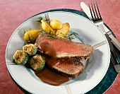 Roasted beef with red wine sauce and zucchini on plate