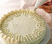 Close-up of butter cream cake with pistachio, decorated with splash wavy line on the edge