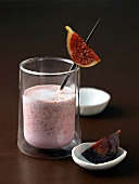 Almond and fig milkshake in glass with fresh fig in the stirrer