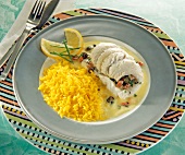 Close-up of fish rolls stuffed with bacon and capers, saffron rice and cream sauce