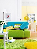 Living room with turquoise-green sofa, dining room in background