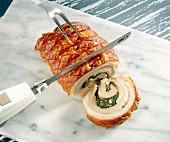 Close-up of electric knife cutting roast meat roll into slices