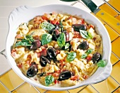 Close-up of egg fried with tomatoes, vegetables, ham, olives and cheese in bowl