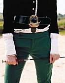 Mid section of woman wearing green pants and belt with gold buckle